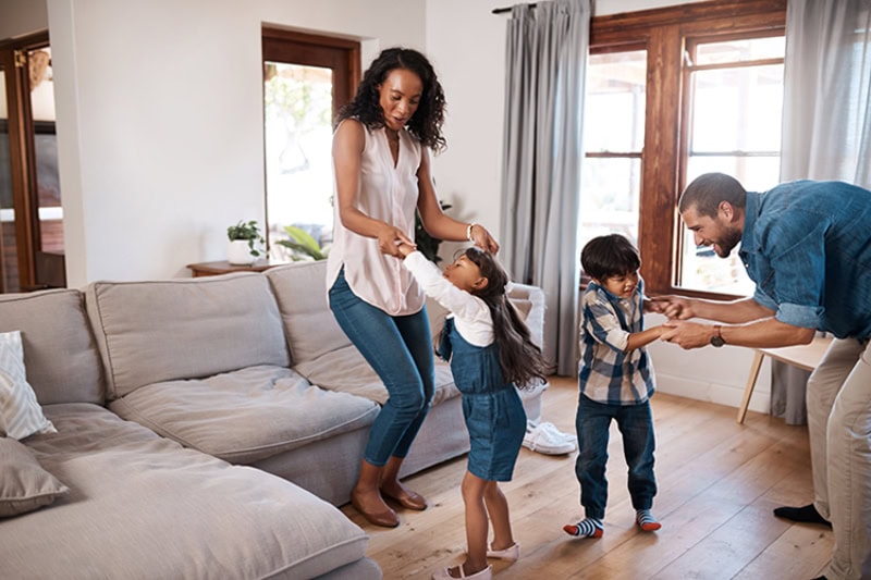 family dancing together in their living room.